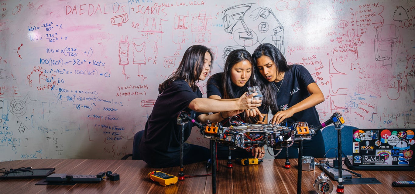 Female students work together on a robotics project.