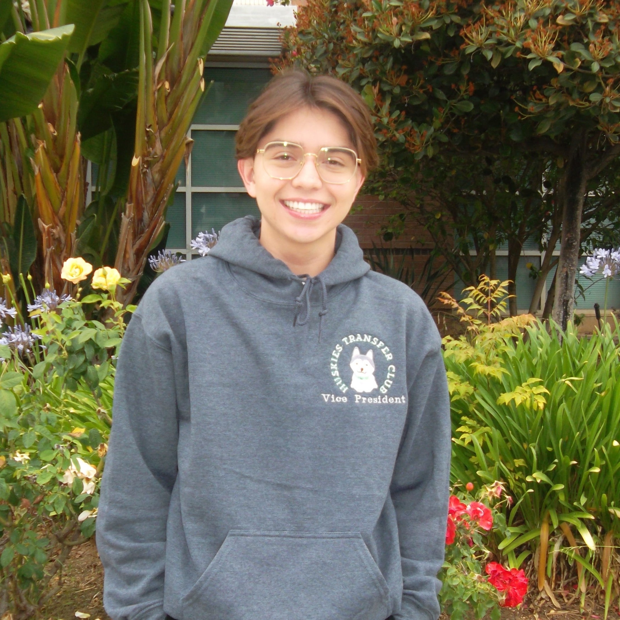 Portrait of Nicholas Armendariz standing in front of a garden