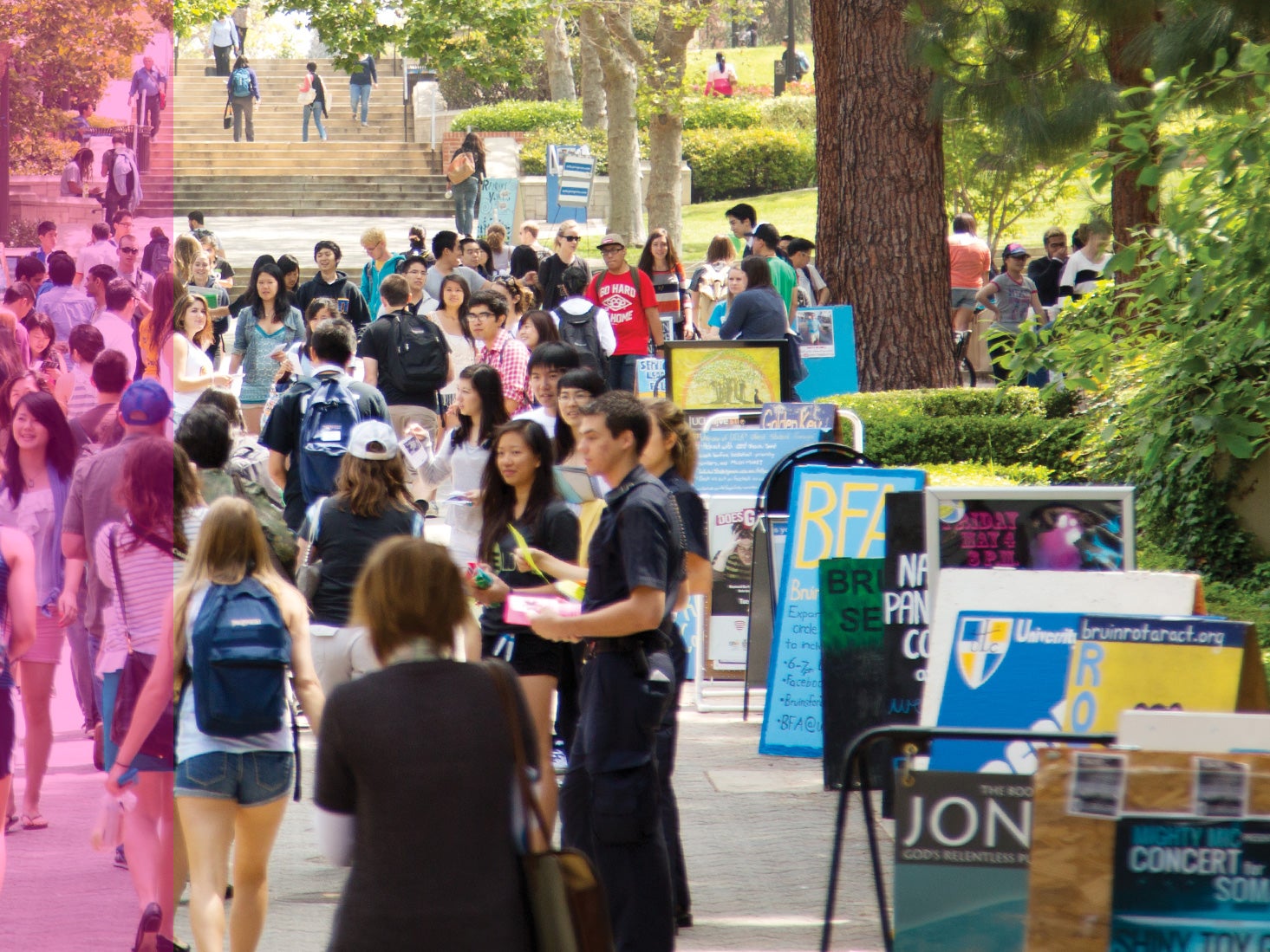 Los estudiantes recorren Bruin Walk, pasando junto a carteles de clubes y organizaciones estudiantiles.