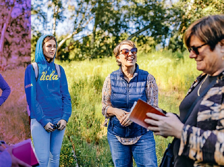 La profesora Victoria Sork hablando con un grupo de estudiantes al aire libre.