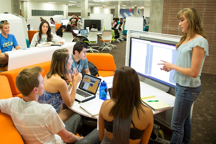 Un instructor habla con un grupo de estudiantes en la Biblioteca de Investigación Charles E. Young.