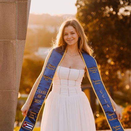Amanda Penichet poses in her dress and graduation sash, which recognizes her achievements.