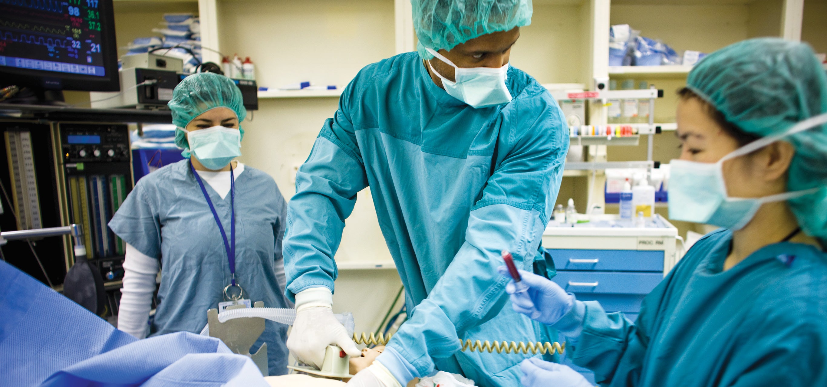 Medical students practice a procedure on a dummy.