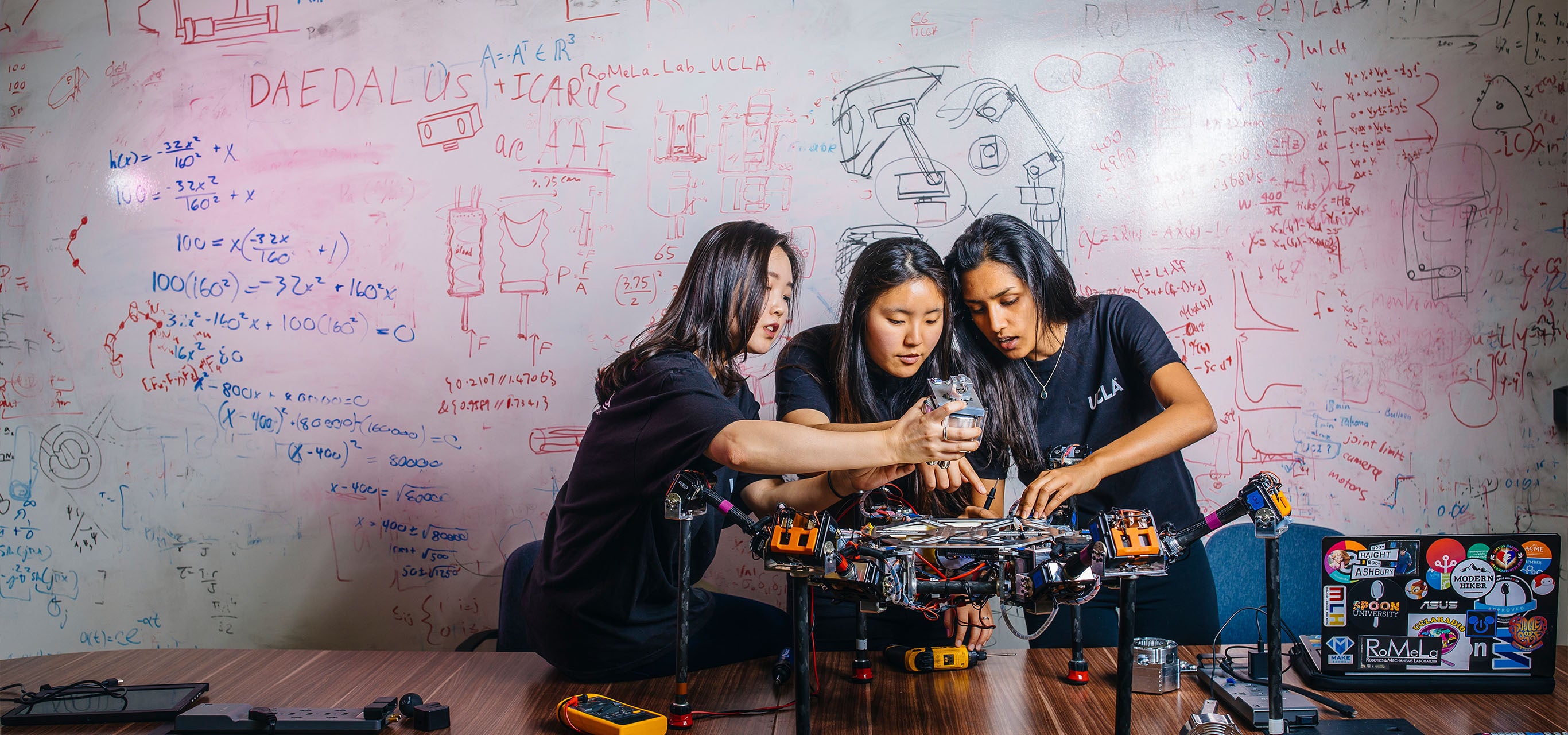 Female students work together on a robotics project.
