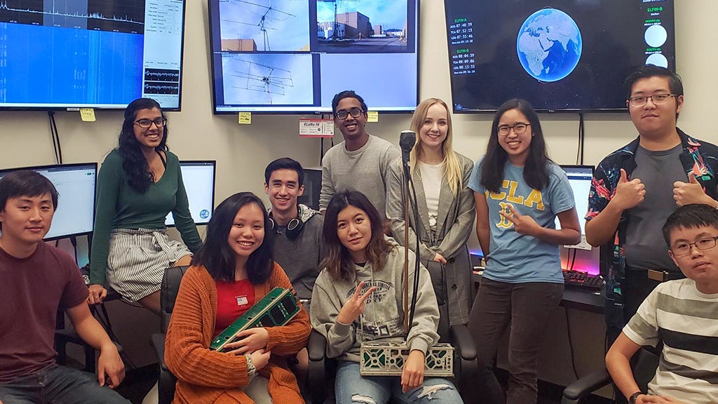 A subset of the ELFIN operations and development poses with two CubeSAT mockups.