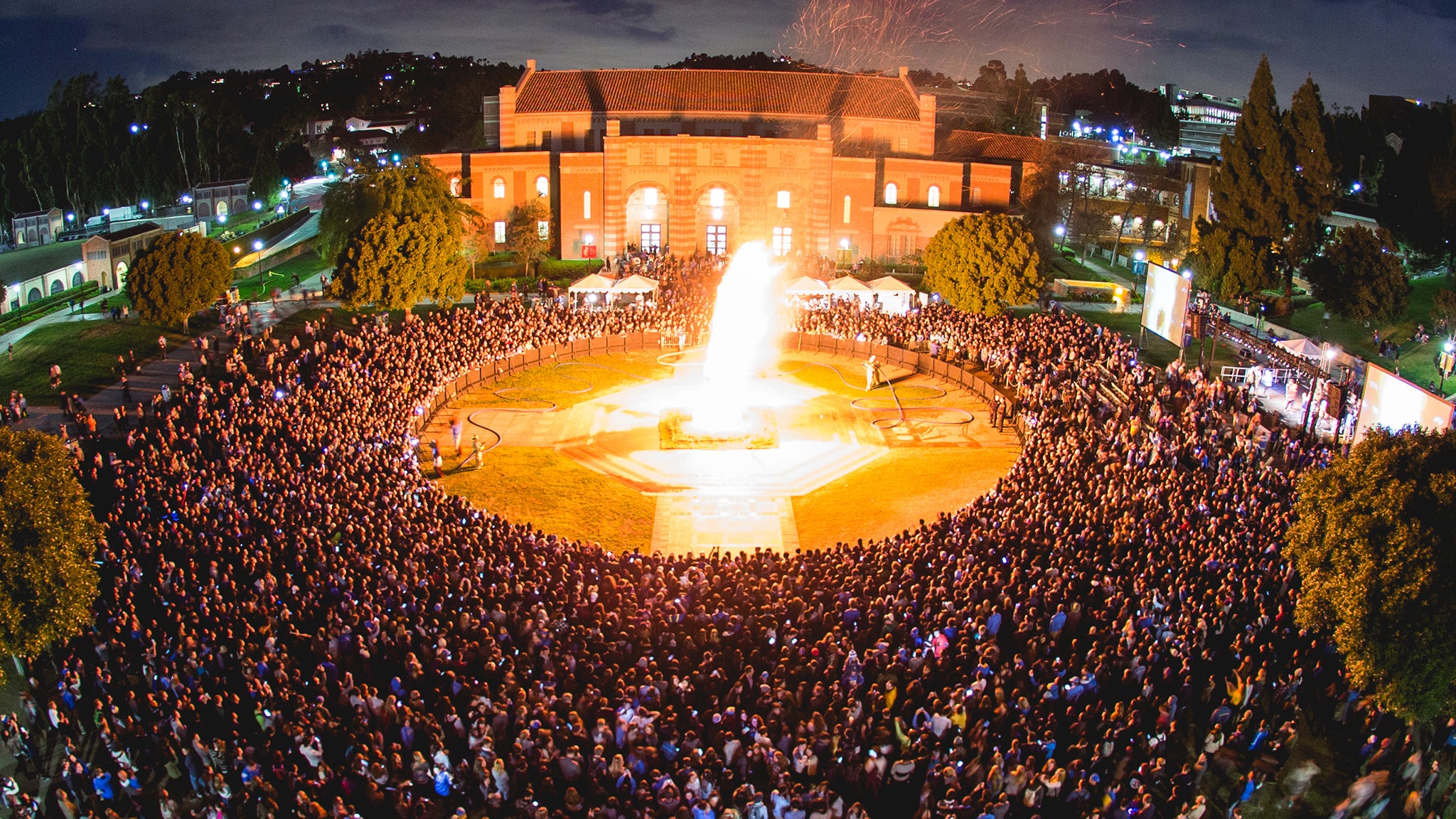 Una gran multitud se congrega alrededor de la enorme llama en la Beat 'SC Bonfire.