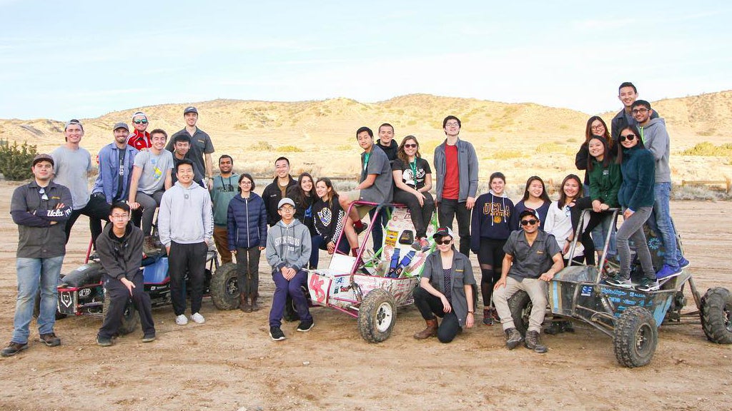 El equipo Bruin Racing Baja SAE posa con algunos vehículos todoterreno.