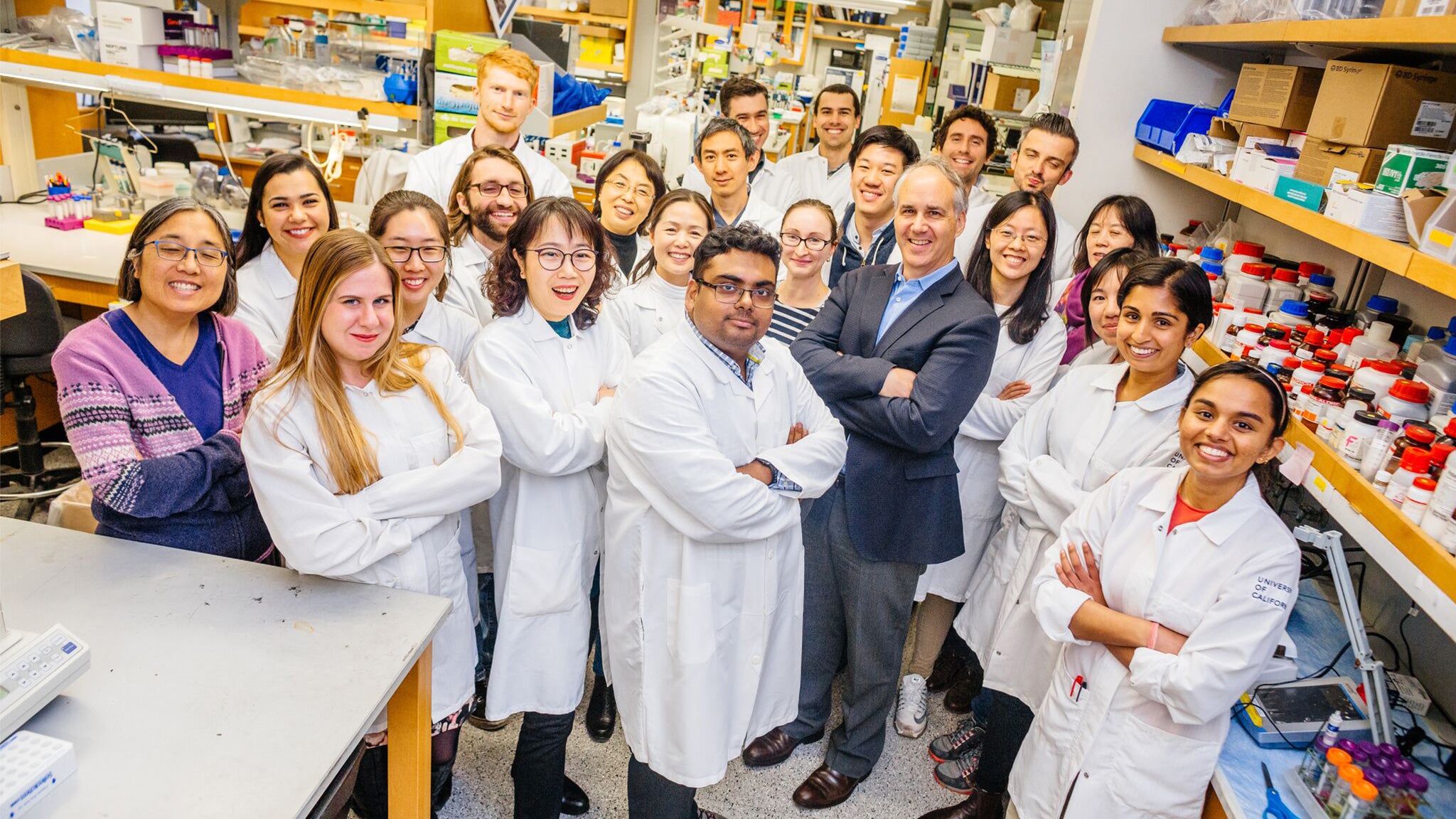 Professor Dan Geschwind smiles along with students in his lab.