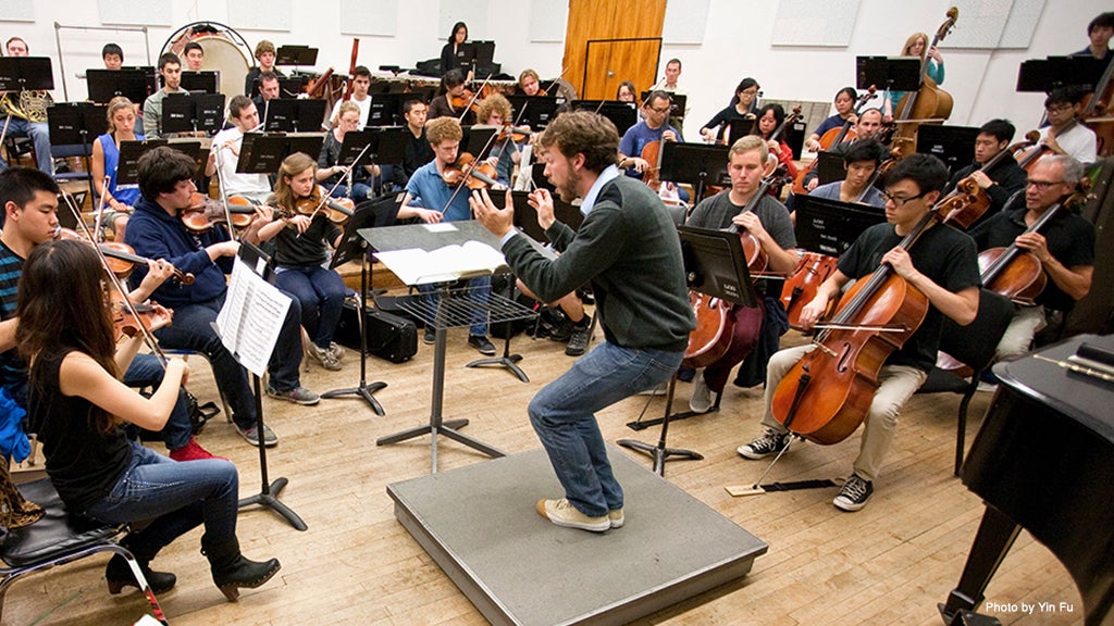 A doctoral student conducts the UCLA Symphony, which is comprised of music and non-music students.