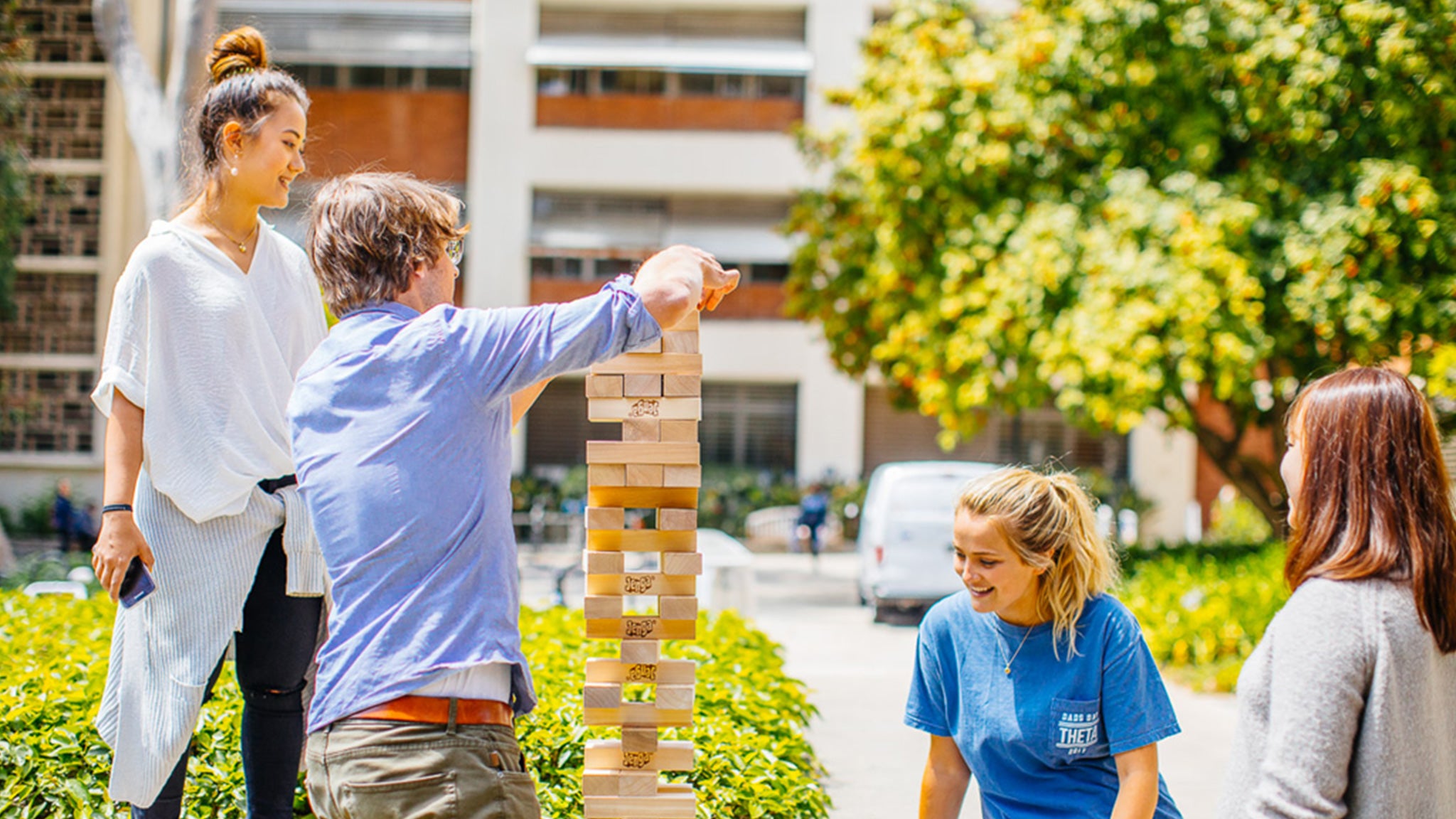 Students play a game of Jenga together outdoors on the Hill.