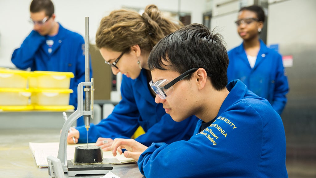 Professor Tracy Johnson looks on as students do research in her lab.