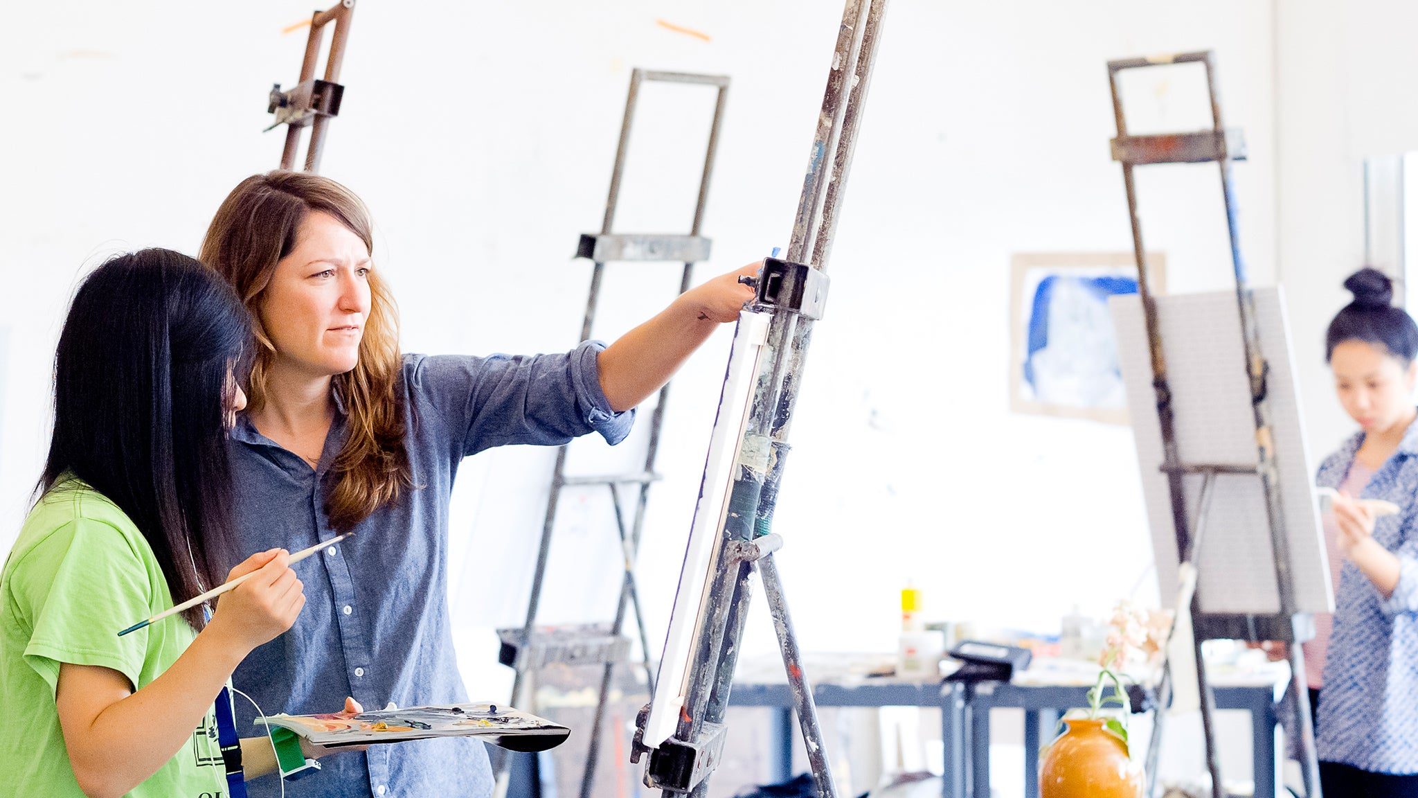 A fine arts student gets feedback on her painting in the Eli and Edythe Broad Art Center.