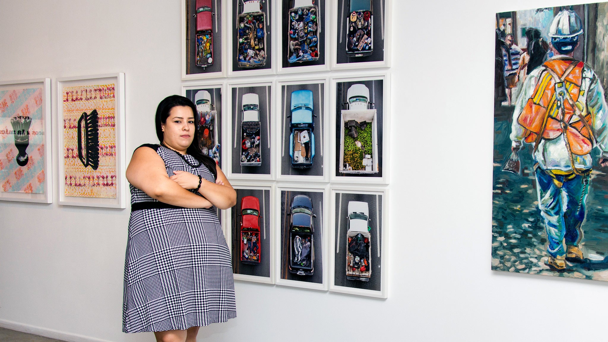 Erika Hirugami poses in front of photos that are part of the art show she curated.