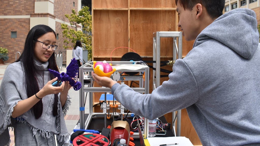 Two members of the 3-D printing club look at the projects they’re working on.