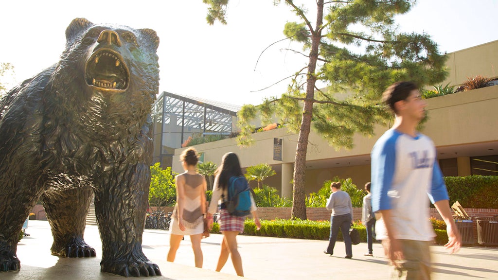 Los estudiantes pasan por la Estatua de The Bruin y el Centro John Wooden.