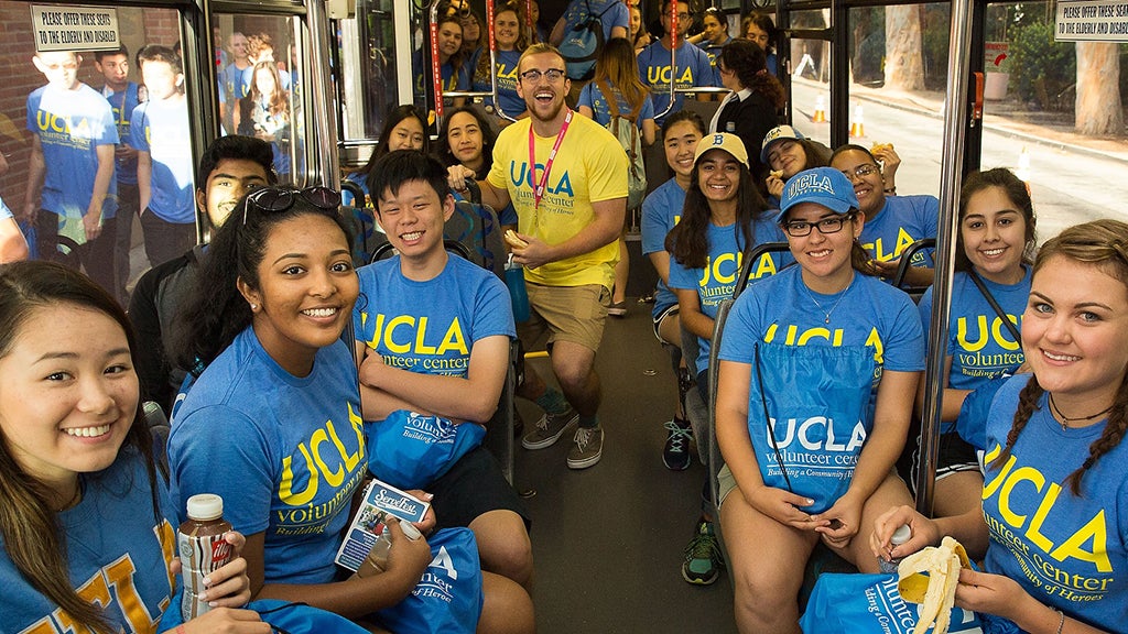 Los participantes del Día del Voluntariado viajan juntos en autobús de camino a un evento benéfico.